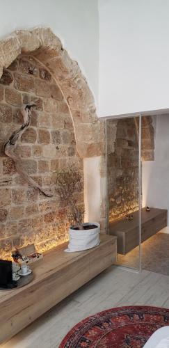 a living room with a stone wall with a fireplace at Akotika boutique in ‘Akko
