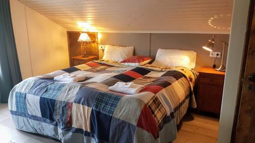 a bedroom with a large bed with towels on it at Grásteinn Guesthouse in Þórshöfn