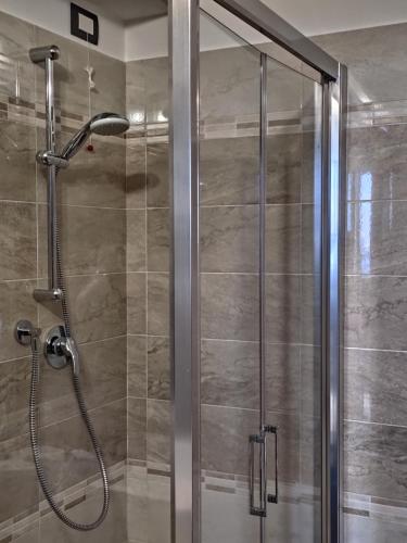 La salle de bains est pourvue d'une douche avec une porte en verre. dans l'établissement Hotel Internazionale, à Ancône