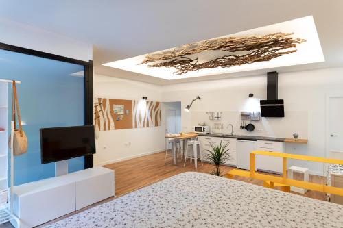a living room with a tv and a kitchen at Suite Nest in Padrón