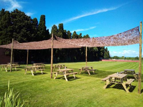 un grupo de mesas de picnic en un campo en La Masia, en Sant Pere Pescador