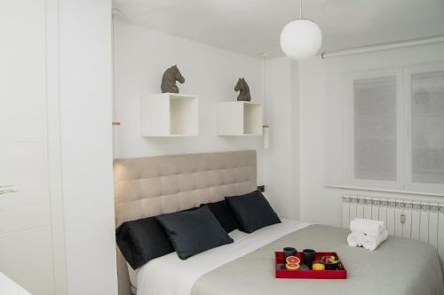 Un dormitorio con una cama con una bandeja de comida. en El Rincón de Eva en Salamanca