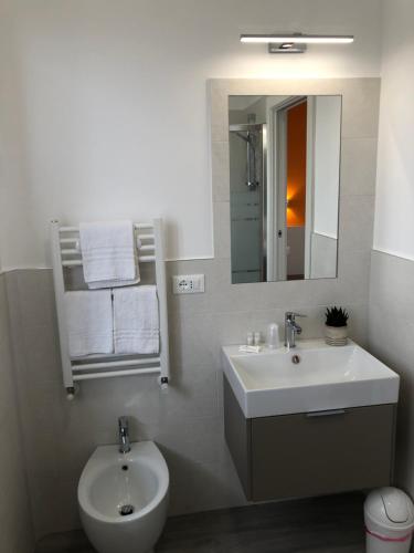 a white bathroom with a sink and a mirror at Nel Conero Affittacamere in Numana