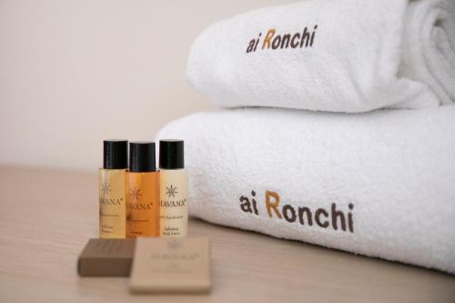 een stapel handdoeken en een fles lotion naast de handdoeken bij Ai Ronchi B&B in Riva di Solto