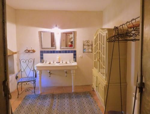 une salle de bain avec un lavabo et un miroir dans l'établissement Les Buis de Lussan, à Lussan