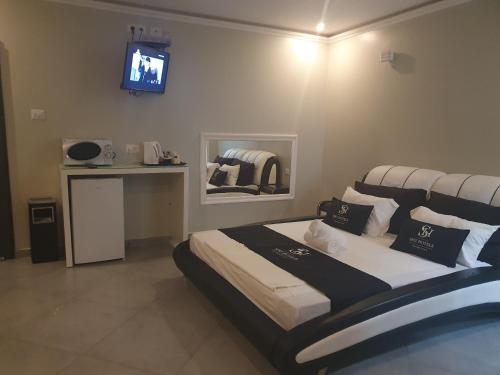 een slaapkamer met een bed en een tv aan de muur bij Spat Business Holon in H̱olon