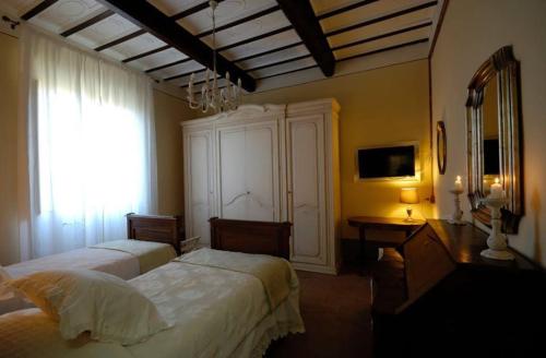 um quarto com 2 camas, uma secretária e uma janela em B&B Cimamori em Poggibonsi