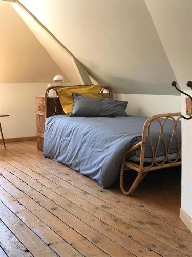 1 dormitorio con 1 cama y suelo de madera en AU NAIN ROUGE gite vintage de charme, en Cormeilles