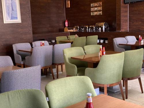 un restaurante con mesas y sillas y un bar en Crystal Blue Hotel, en Rabigh