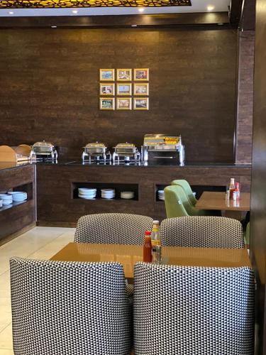 a restaurant with a table and chairs and a counter at ALJAWHARA ALZARQAA FOR SERVISED APARTMENTS Est in Rabigh