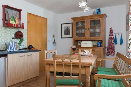 uma cozinha com uma mesa de madeira e uma sala de jantar em Ferienwohnung Stein mit Sauna em Hasselbach