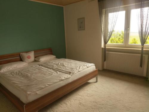 1 dormitorio con cama y ventana grande en Ferienwohnung Wolf en Tittling