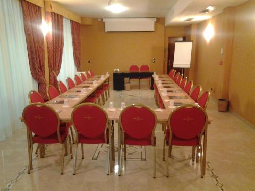 a conference room with a long table and red chairs at Hotel Marconi in Milan