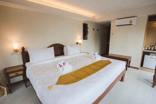 a hotel room with a bed and a lamp at Chada Mantra Hotel in Chiang Mai