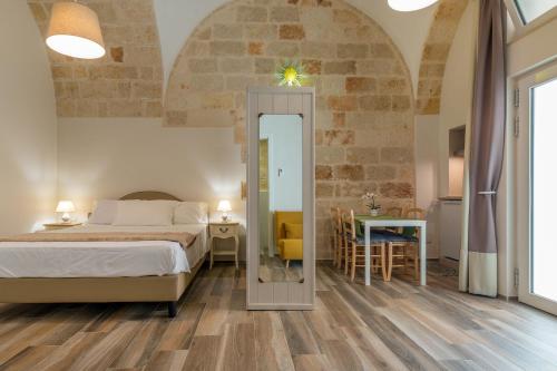 a bedroom with a bed and a table and a mirror at Dimora Cavour in Polignano a Mare