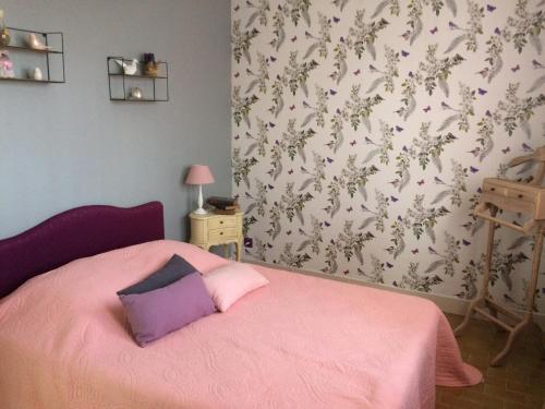 - une chambre avec un lit rose et une couverture rose dans l'établissement Le tulipier, à Manneville-la-Raoult