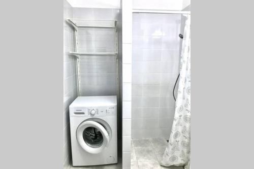 a washing machine in a bathroom next to a shower at Cozy Studio near the center of Cluj in Cluj-Napoca