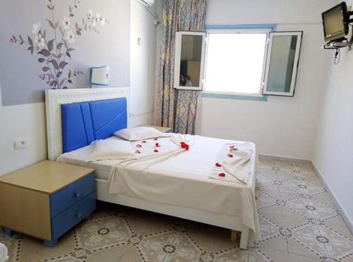 a bedroom with a bed with red flowers on it at Houria House Sable D'or in Mahdia