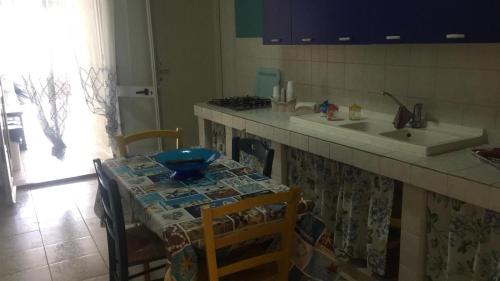 uma cozinha com uma mesa, um lavatório e um balcão em Casa Sciatu di Mari em Portopalo