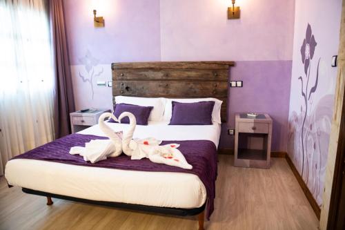 a bedroom with two swans towels on a bed at Posada la Leyenda in Santillana del Mar