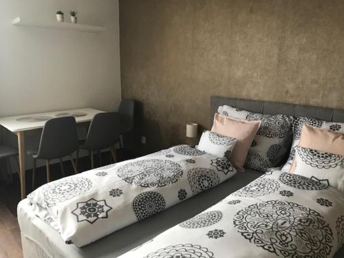 a bedroom with two beds and a table with chairs at Apartmán Innova in Zlín