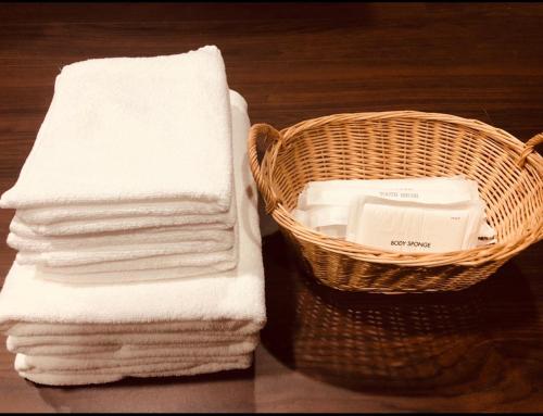 a basket of towels next to a stack of towels at Utatei Sou in Takayama