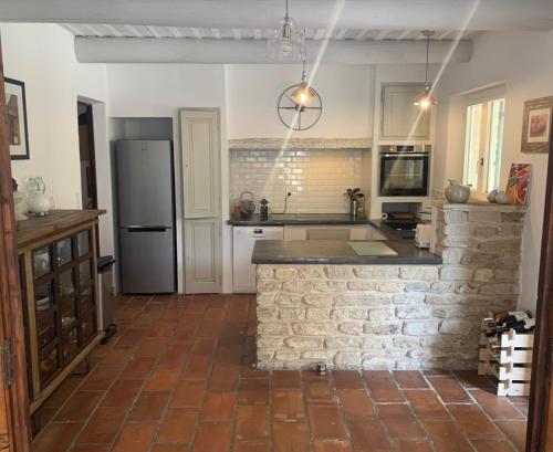 a kitchen with a brick wall and a refrigerator at Lou Mas in Gordes