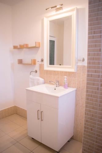 a bathroom with a white sink and a mirror at pensiunea vanesa in Baile Felix