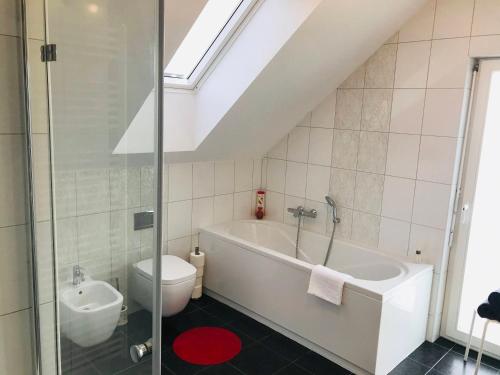 La salle de bains est pourvue d'une baignoire blanche et de toilettes. dans l'établissement Family house in Bled region, à Radovljica