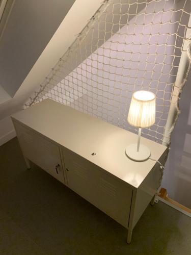 Ambiance bois - 2 appartements في فان: طاولة عليها مصباح في الغرفة