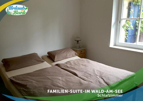 En eller flere senge i et værelse på Familien-Suite-im-Wald-am-See