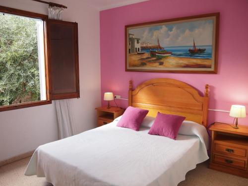 a bedroom with a bed with purple walls and a window at Chalet Sa Marina in Port d'Alcudia