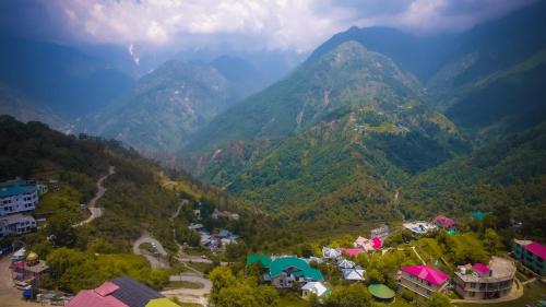 an aerial view of a mountain valley with houses and buildings at Hotel Udechee Huts, McLeod Ganj in McLeod Ganj