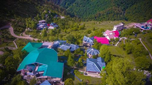 an aerial view of a house in a mountain at Hotel Udechee Huts, McLeod Ganj in McLeod Ganj