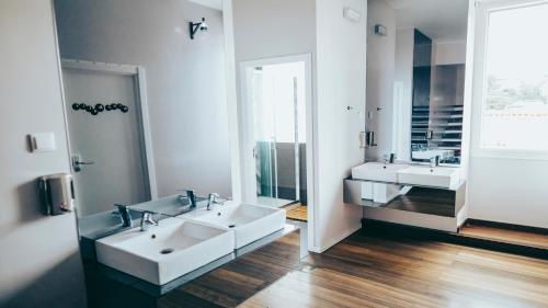 a bathroom with two sinks and a large mirror at Gspot Hostels & Love Triangles Pizzeria in Lisbon