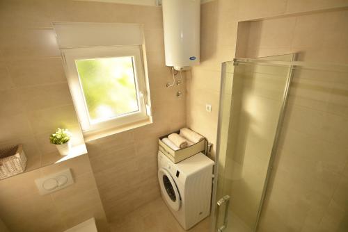 a small bathroom with a shower and a window at Apartments Ivanica and Mirela in Jadranovo