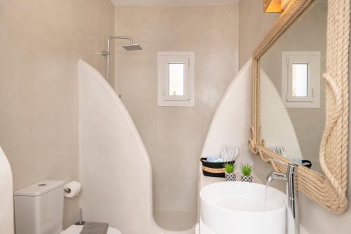 y baño con bañera blanca y lavamanos. en Salty Villas, Chrissipi, en Antíparos