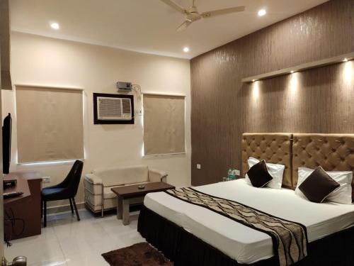 a bedroom with a bed and a desk and a chair at Maple Delite in Lucknow