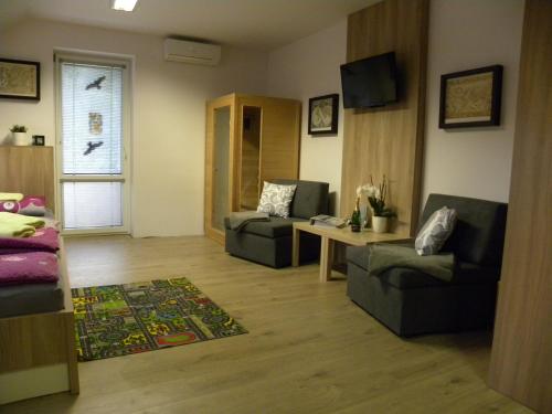 a living room with two couches and a table at Apartment WELLNESS Vlčková in Vlčková