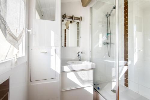 Un baño blanco con lavabo y ducha. en Studio Vue Mer, en Saint-Martin-de-Ré