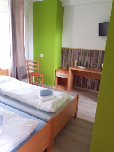 1 dormitorio con 2 camas, escritorio y silla en Guesthouse Osvald, en Žirovnica