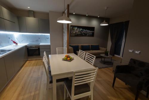 a kitchen and living room with a table and chairs at Porta Apartament in Vlorë