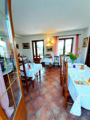 a dining room with white tables and chairs at Il Vecchio Noce in Brugnato