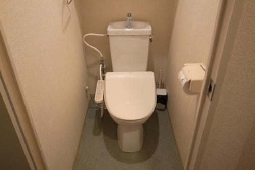 a small bathroom with a toilet in a stall at KYOTO SANJO Inn 京都三条イン in Kyoto