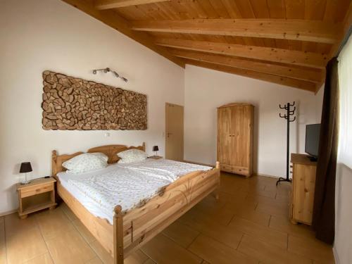 a bedroom with a wooden bed and a tv at Ferienhaus Plattenstein in Kirchberg