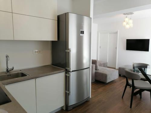 einen Kühlschrank aus Edelstahl in einer Küche mit einem Tisch in der Unterkunft Penthouse MareMonte in Omiš