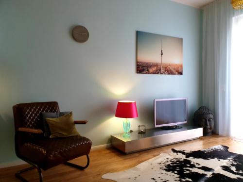een woonkamer met een stoel en een televisie bij Apartment P1 in Berlin-Friedrichshain in Berlijn
