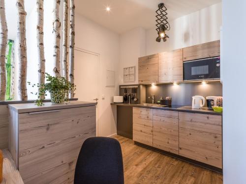 a kitchen with wooden cabinets and a chair in a room at Aparthotel Backstage in Kufstein