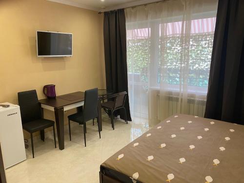 a bedroom with a table and a bed and a television at Міні-готель "Кімната Комфорт" in Odesa
