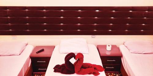 Emerald Hotel في القاهرة: قارب عليه سريرين مع قفازات حمراء